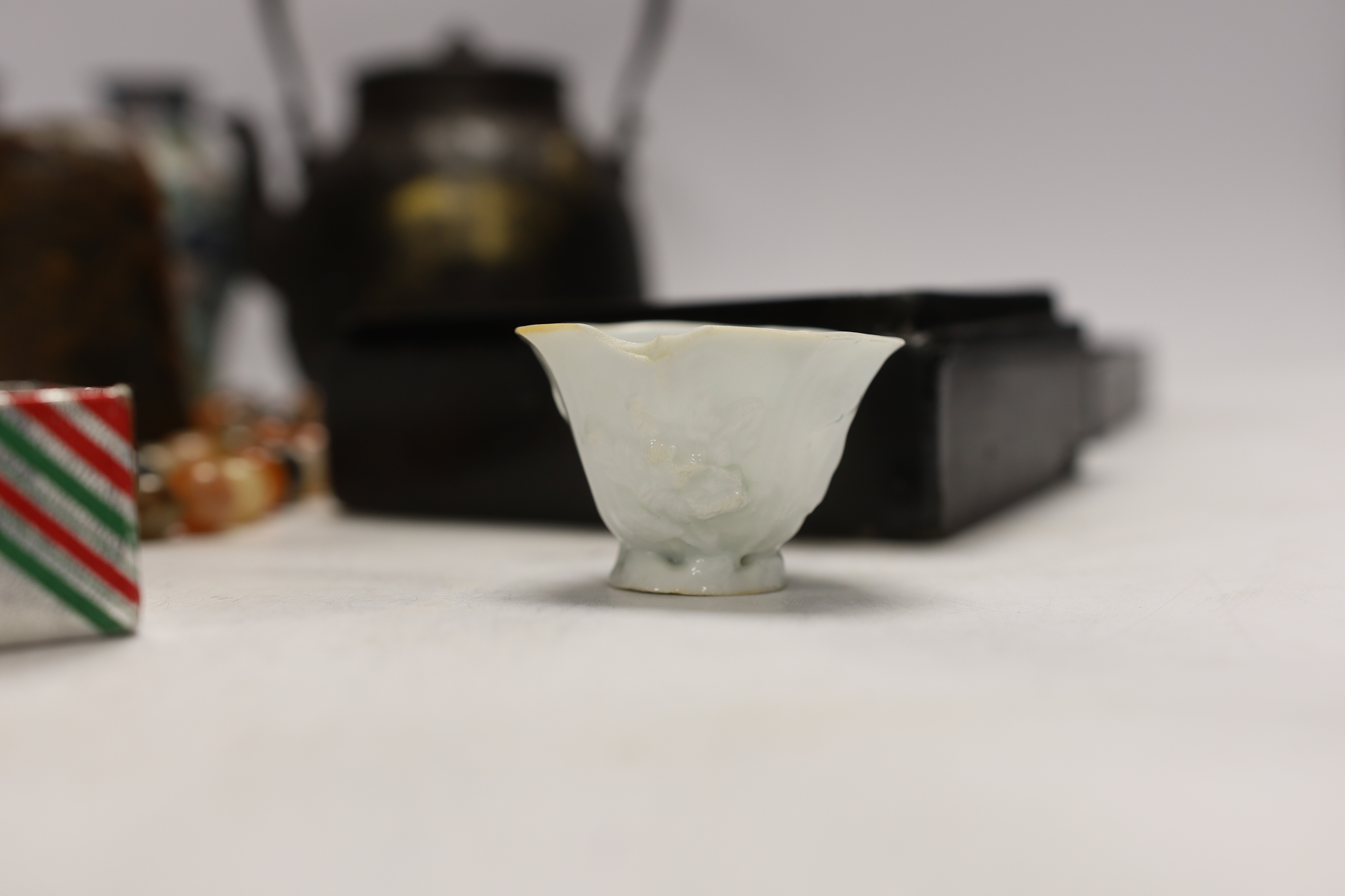 A Japanese iron tetsubin kettle with gilt decoration, a pair of Chinese cloisonné enamel vases, 12.5cm, a lacquered box with mother of pearl inlay, a carved black stone disc, 5cm diameter, a miniature ceramic pot and an